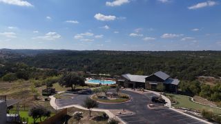 Breathtaking hill views with a community pool and lush landscaping in Sweetwater by Chesmar Homes (Austin, TX).