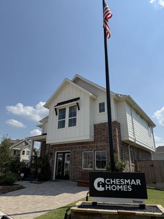 Street view A charming brick and siding home in Sienna by Chesmar Homes, Missouri City, TX, with a welcoming front entrance.
