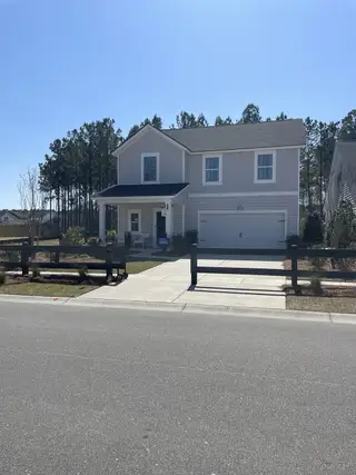 Street view A charming two-story home with a covered porch in Heron's Walk at Summers Corner: Coastal Collection by Lennar (Ridgeville, SC).