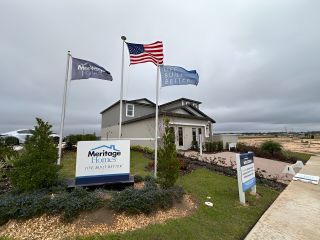A charming gray home with a landscaped yard in Springs at Lake Alfred - Classic Series by Meritage Homes (Lake Alfred, FL).