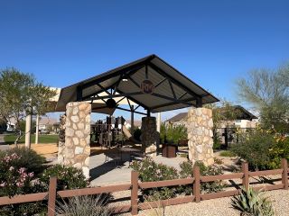 A charming park pavilion with stone pillars and lush landscaping in Los Cielos at Rancho Mercado by Taylor Morrison (Surprise, AZ).