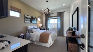 A cozy bedroom featuring a plush bed, wooden accents, soft lighting, and elegant curtains for a serene atmosphere.