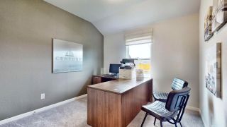 A modern office space with a wooden desk, wall art, and natural light from a window, creating an inviting work environment.