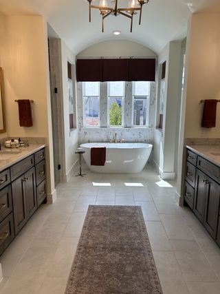 Model Home A luxurious bathroom featuring an elegant freestanding tub, dual vanities, and stylish lighting.