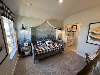 Model Home Cozy bedroom with forest-themed mural, checkered bedding, and an adjoining bathroom featuring modern decor.