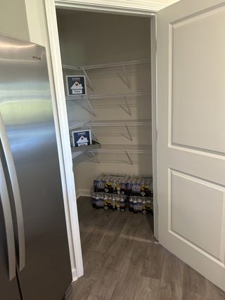 A spacious pantry with sleek gray flooring, metal shelving, and ample storage space for all your kitchen essentials.