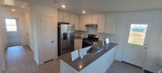 Model Home A modern kitchen featuring sleek countertops, stainless steel appliances, and ample cabinetry for storage.