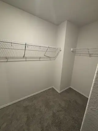 A spacious walk-in closet with soft carpet and ample wire shelving for organized storage.