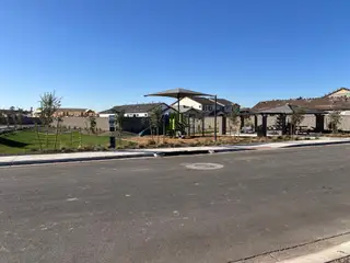 A charming community park with a playground and greenery in Village at Pioneer Crossing by Blandford Homes (Mesa, AZ).