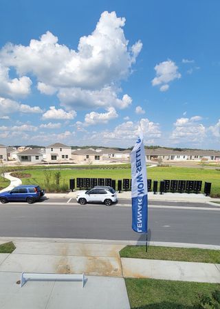 Modern homes in Westview: Aden South II by Lennar, Kissimmee, FL, under a vibrant blue sky with beautiful clouds.