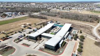 Community Amenities A modern community center with a pool in Easton Park by Pacesetter Homes, surrounded by lush greenery and scenic views (Austin, TX).