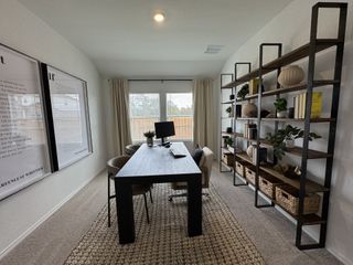 A modern home office with large windows, chic shelving, and a sleek dark wood desk, perfect for productivity.