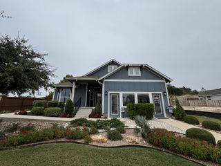 A charming gray home with a manicured yard in Orchard Ridge by Pacesetter Homes (Liberty Hill, TX).