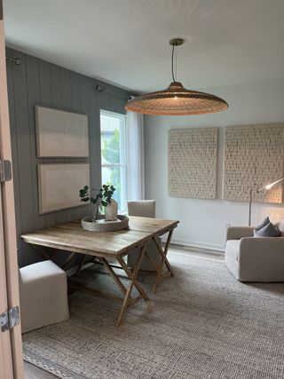 Model Home A cozy study nook with a rustic wood table, plush chairs, and a woven pendant light, set against a serene color palette.