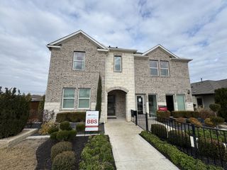 A beautiful brick home with arched entry and manicured landscaping in Emory Crossing 40s by Taylor Morrison, Hutto, TX.