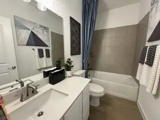 Model Home A modern bathroom featuring a sleek vanity, elegant tiles, and stylish decor with contemporary art.