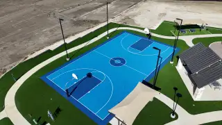 Community Amenities A vibrant blue basketball court and pavilion in Rancho Del Cielo by Lennar (Jarrell, TX).