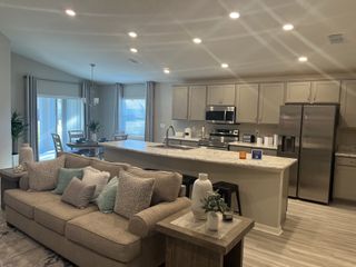 A cozy open-concept kitchen and living area with modern appliances, neutral tones, and stylish decor.
