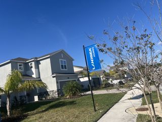 A modern gray home with landscaped yard in The Gardens at Waterstone by Landsea Homes (Palm Bay, FL).