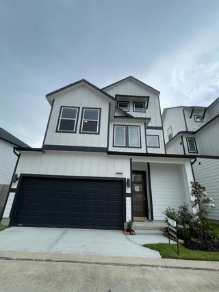 A modern white-paneled home with dark accents in Regents Court by Colina Homes (Houston, TX).
