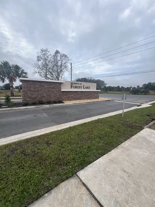 Welcoming entrance to Reserve at Forest Lake Townhomes by KB Home, set amidst lush scenery in Lake Wales, FL.