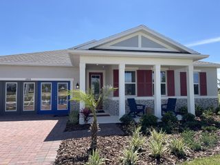 A charming home with red shutters and a landscaped yard in Meadowlark Landing by Mattamy Homes (Apopka, FL).