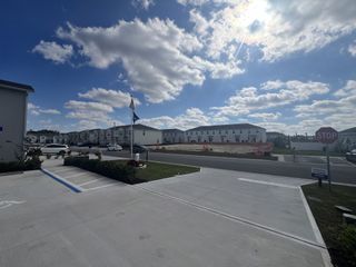 Modern townhomes with spacious driveways under a bright sky in Danbury at Ridgewood Lakes by D.R. Horton (Davenport, FL).
