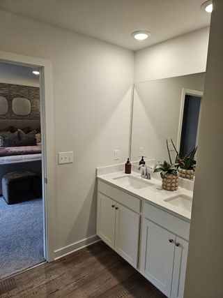 A stylish vanity area with dual sinks, white cabinetry, and elegant lighting.