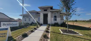 Bright and welcoming model home with a spacious front yard in Veranda by Brightland Homes (San Antonio, TX).