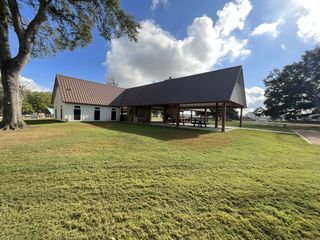A modern pavilion with a metal roof and picnic tables, perfect for gatherings and outdoor fun.