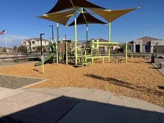 A vibrant playground with shade structures in Miravida by Mattamy Homes, set amid scenic homes in Surprise, AZ.