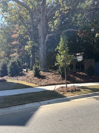 A serene entrance flanked by mature trees in Galloway Towns by Pulte Homes, Charlotte, NC.