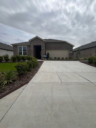 Street view A charming brick home with a spacious driveway in Del Webb at Trinity Falls by Del Webb (McKinney, TX).