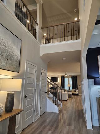 A high-ceiling foyer with elegant iron railings and wood flooring in Kingston by DRB Homes (Locust Grove, GA).