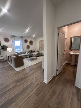 A cozy living room with elegant décor, hardwood floors, and a glimpse into a modern bathroom.
