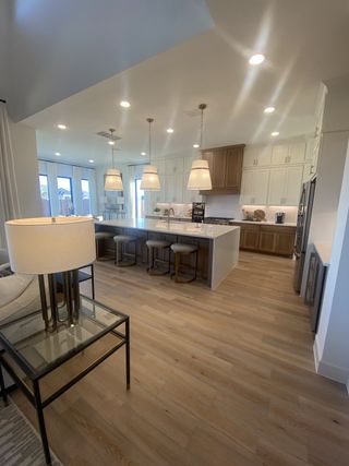 Model Home A sleek kitchen with pendant lighting, an oversized island, and ample cabinet storage, blending function with beauty.