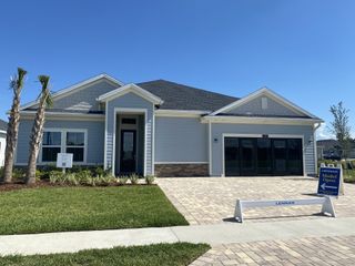 Street view A modern single-story home with elegant gray siding and a manicured lawn in SilverLeaf: Silver Meadows 60s by Lennar (St. Augustine, FL).