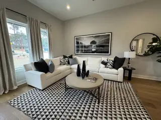 Stylish living space with a white sectional, modern decor, and large windows letting in natural light.