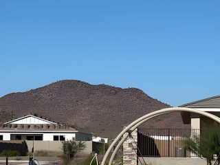 A scenic view of a home with mountain backdrop in Windstone Ranch: Signature by Lennar (Surprise, AZ).