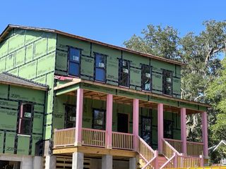 Street view Under-construction home with pink columns in Enclave at Palmetto Fort by Homes by Dickerson (Mount Pleasant, SC).