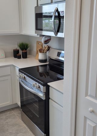 A modern kitchen with sleek appliances, white cabinetry, and stylish countertops.