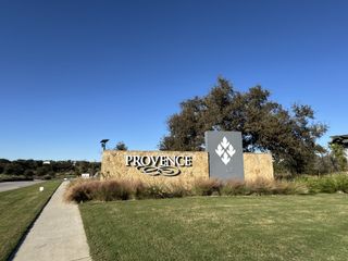 Street view Welcome to Provence 70s by Ashton Woods in Austin, TX, featuring lush landscapes and natural beauty.