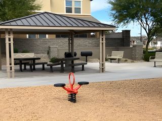 Community Amenities A charming community playground with a covered seating area and grill in Redwood Valley at Escalante by Fulton Homes (Surprise, AZ).