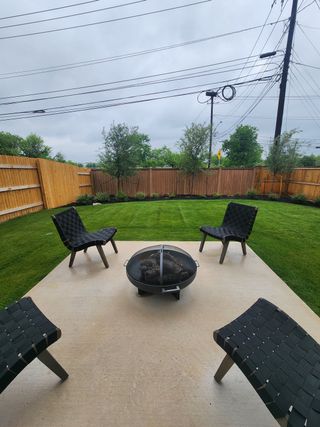 Model Home A cozy backyard patio with modern seating and a fire pit, perfect for outdoor relaxation and entertaining.