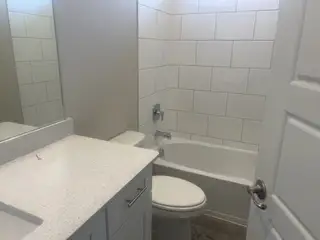 A sleek bathroom featuring white subway tiles, a modern sink, and elegant fixtures.