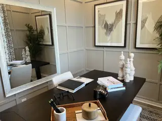 Model Home A chic home office with abstract art, decorative accents, and a sleek desk creating a modern, cozy workspace.