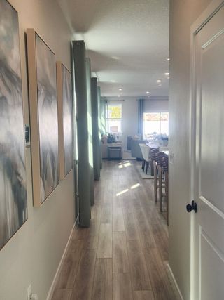 A bright hallway with contemporary artwork, high ceilings, and wood-look flooring, creating a seamless flow throughout the home.