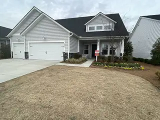 A charming gray home with a manicured garden in Horizons at Summers Corner by Lennar (Summerville, SC).