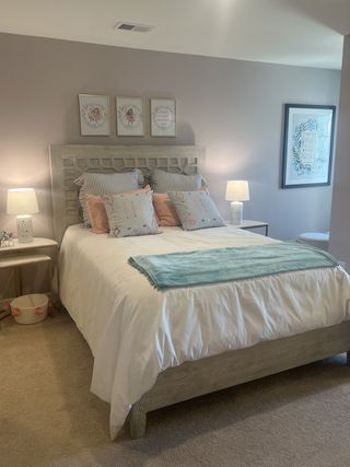 Cozy bedroom with a soft palette, wooden bedframe, stylish bedding, and gentle lighting for a relaxing atmosphere.