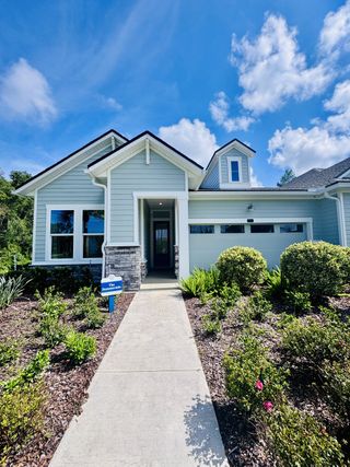 Street view A charming blue home with manicured landscaping in Crosswinds 40' Paired Villas by David Weekley Homes (Ponte Vedra, FL).
